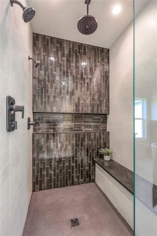 bathroom featuring tiled shower and tile walls