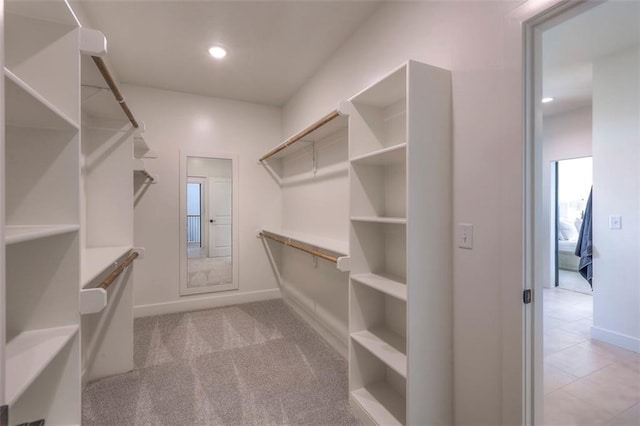 walk in closet featuring light colored carpet