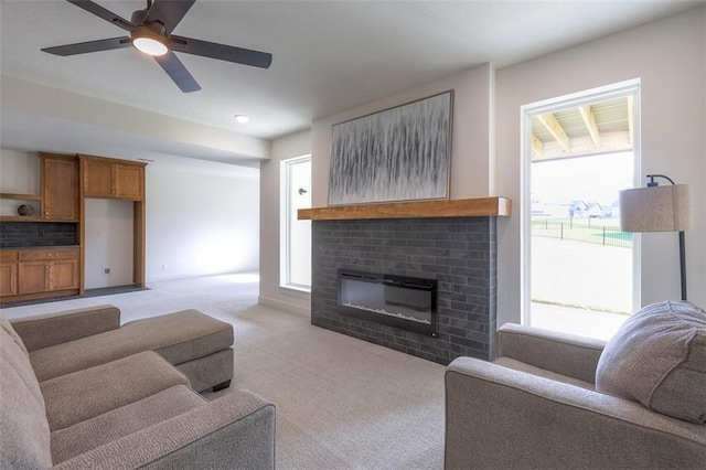 living room with light carpet, ceiling fan, a healthy amount of sunlight, and a brick fireplace