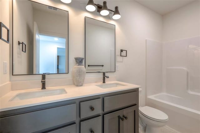 full bathroom featuring vanity, toilet, and  shower combination