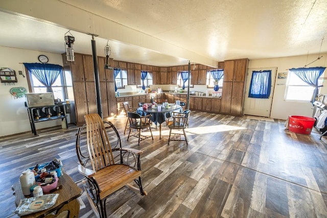 dining room with a textured ceiling and dark wood-type flooring