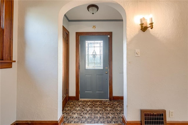 doorway to outside featuring crown molding