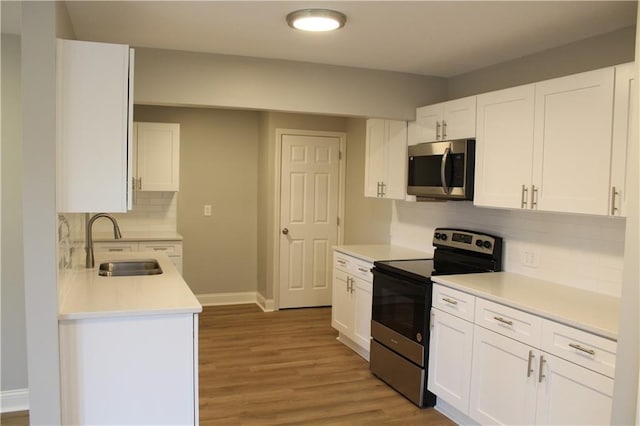 kitchen with tasteful backsplash, stainless steel appliances, sink, light hardwood / wood-style flooring, and white cabinetry