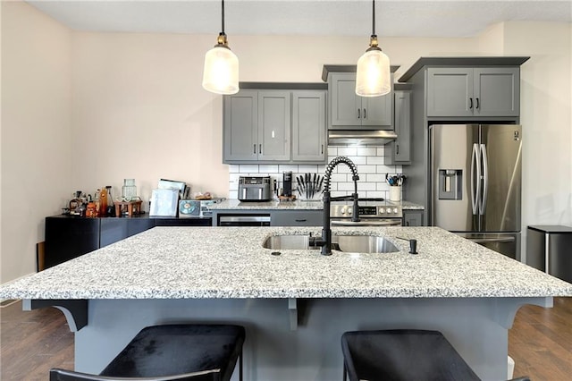 kitchen with stainless steel fridge, sink, hanging light fixtures, and tasteful backsplash