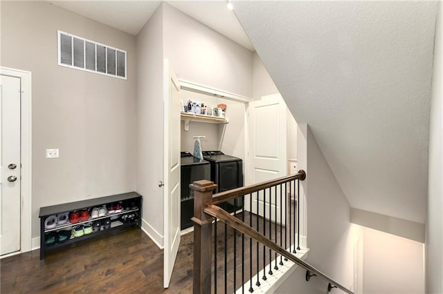 staircase featuring washing machine and dryer and hardwood / wood-style floors