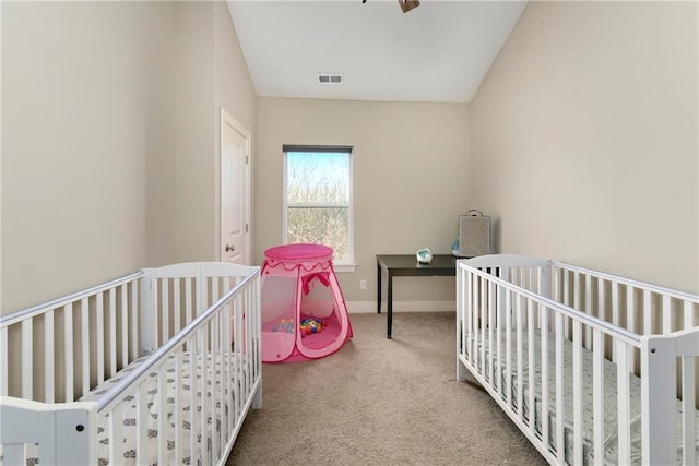 carpeted bedroom featuring a crib and lofted ceiling