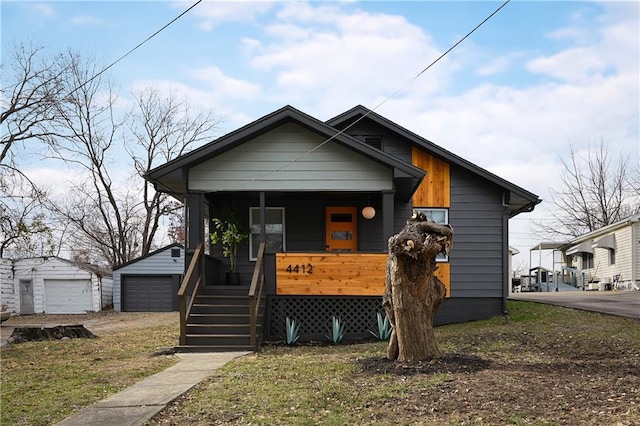 4412 N Jackson Ave, Kansas City, MO 64117 - bungalow-style house featuring a porch, a garage, and an outbuilding