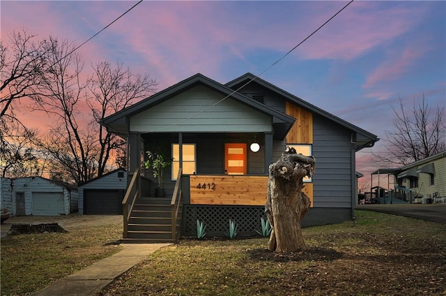 4412 N Jackson Ave, Kansas City, MO 64117 - bungalow with covered porch, a garage, and an outbuilding