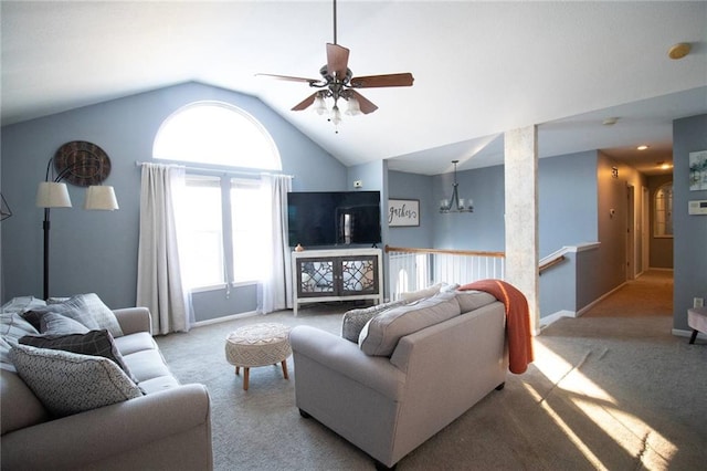 carpeted living room with lofted ceiling and ceiling fan with notable chandelier