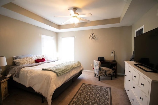 bedroom with ceiling fan, carpet, and a raised ceiling