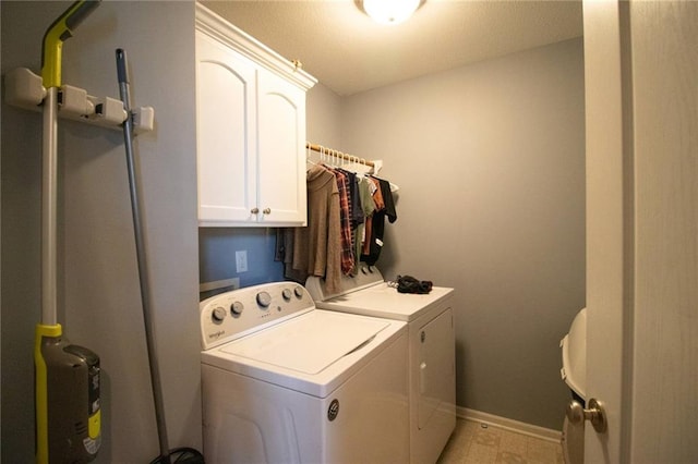 clothes washing area with cabinets and washer and clothes dryer