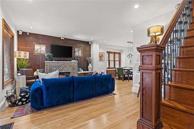 living room featuring light wood-type flooring and a brick fireplace