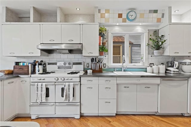 kitchen with white cabinetry, sink, and white stove