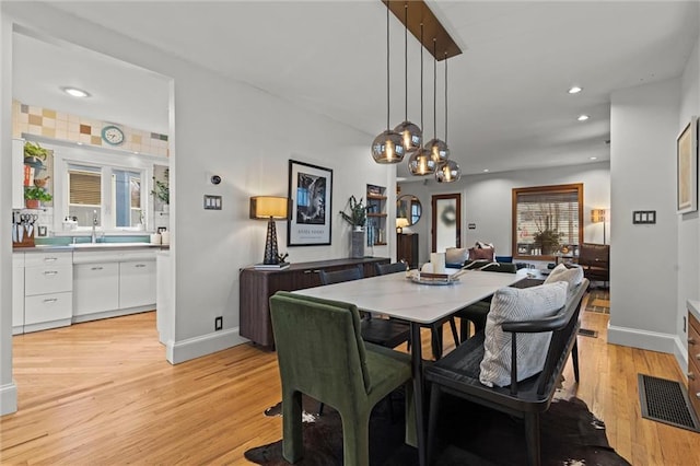 dining room with a healthy amount of sunlight, light hardwood / wood-style floors, and sink