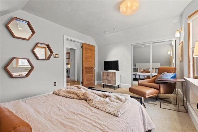 carpeted bedroom featuring a closet and vaulted ceiling