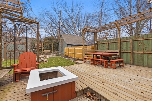 wooden terrace featuring a fire pit and a pergola