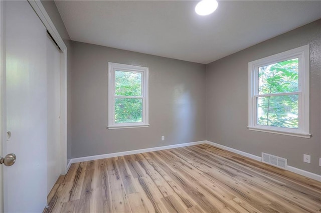 spare room with plenty of natural light and light hardwood / wood-style floors