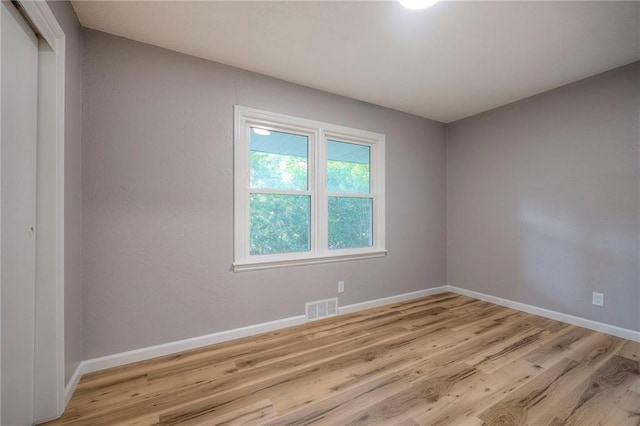 unfurnished room with light wood-type flooring