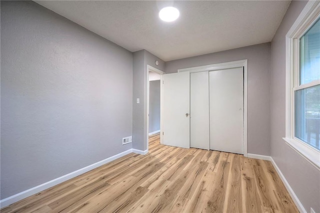 unfurnished bedroom featuring a closet and light wood-type flooring