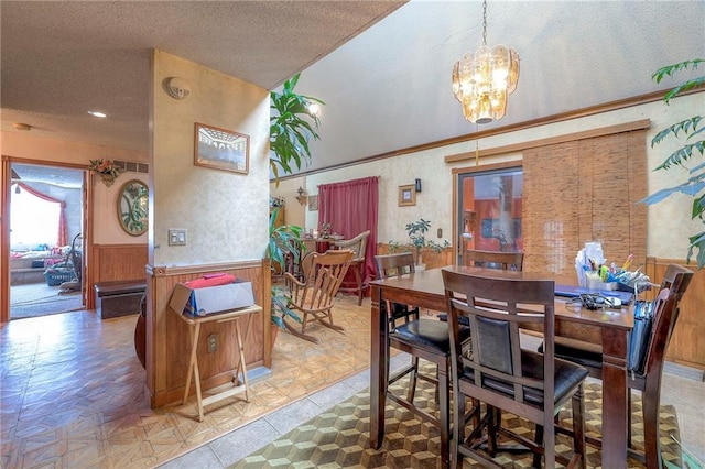 dining space with a textured ceiling, an inviting chandelier, and light parquet flooring