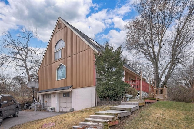 view of side of property featuring a garage, a yard, and a deck