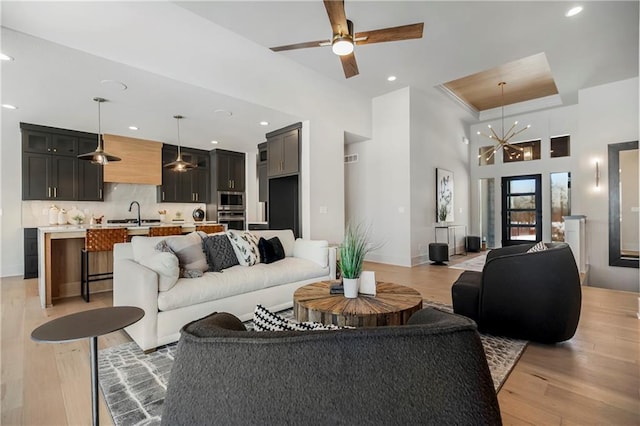 16781 S Fellows St, Olathe, KS 66062 - living room featuring light wood-style flooring, a high ceiling, recessed lighting, ceiling fan, and a chandelier