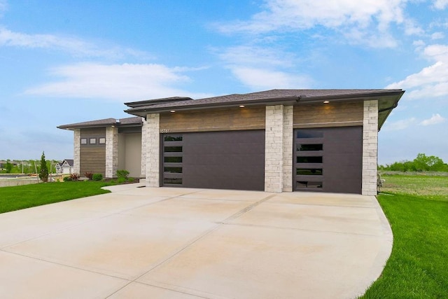 16781 S Fellows St, Olathe, KS 66062 - prairie-style home featuring stone siding, a front lawn, a garage, and concrete driveway