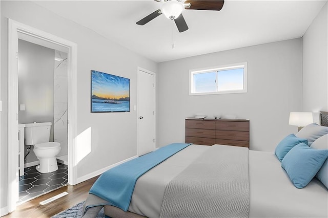 bedroom with dark wood-type flooring, ceiling fan, and ensuite bathroom