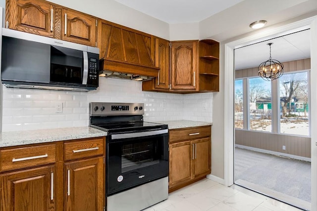 kitchen featuring tasteful backsplash, a chandelier, hanging light fixtures, appliances with stainless steel finishes, and light stone countertops