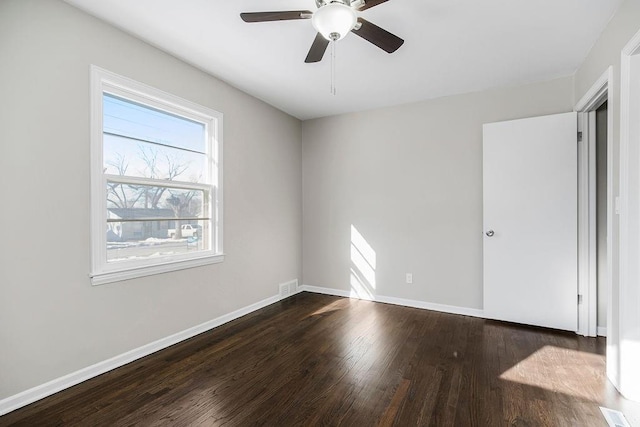 spare room featuring dark hardwood / wood-style flooring and ceiling fan