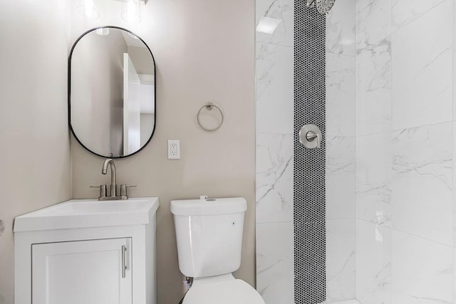 bathroom featuring tiled shower, vanity, and toilet