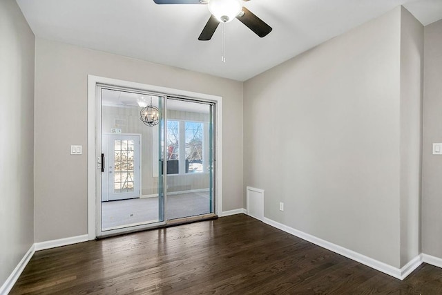 unfurnished room featuring ceiling fan with notable chandelier and dark hardwood / wood-style floors