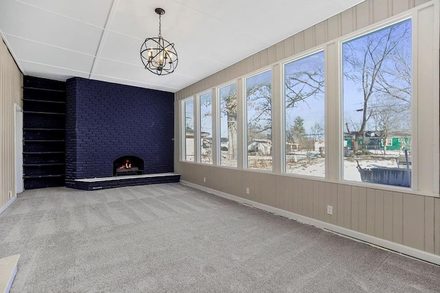 interior space with a fireplace, a chandelier, and plenty of natural light