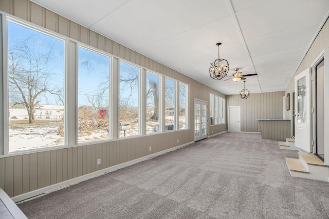 unfurnished sunroom featuring plenty of natural light and a chandelier