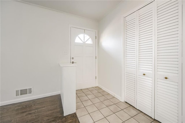 foyer featuring light wood-type flooring and ornamental molding