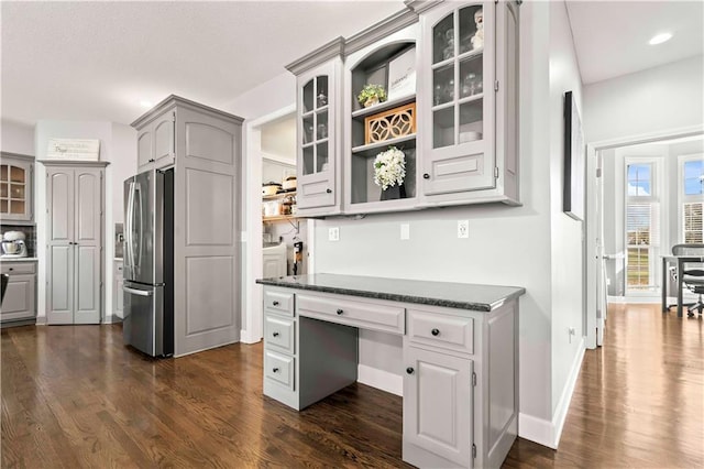 kitchen featuring dark hardwood / wood-style floors, built in desk, stainless steel fridge, and gray cabinetry