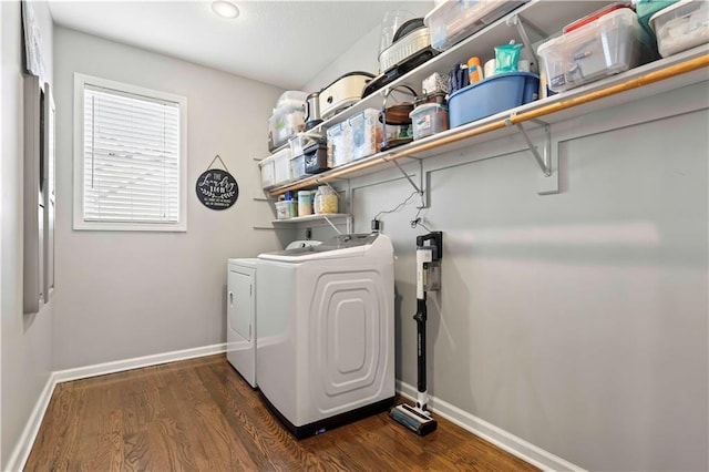 clothes washing area with dark wood-type flooring and independent washer and dryer