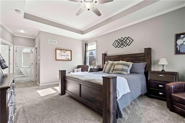 carpeted bedroom with a tray ceiling, ornamental molding, and ceiling fan