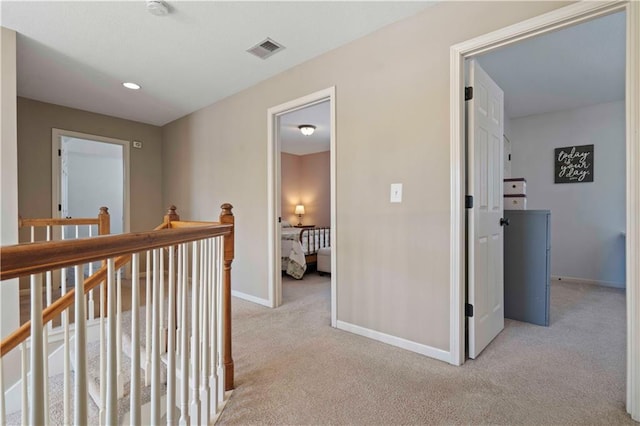 hall with light colored carpet