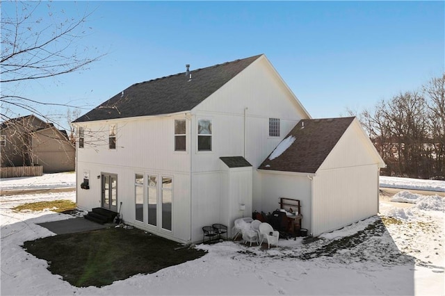 view of snow covered rear of property