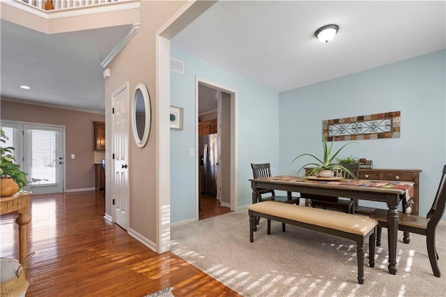 dining space featuring ornamental molding and dark hardwood / wood-style floors