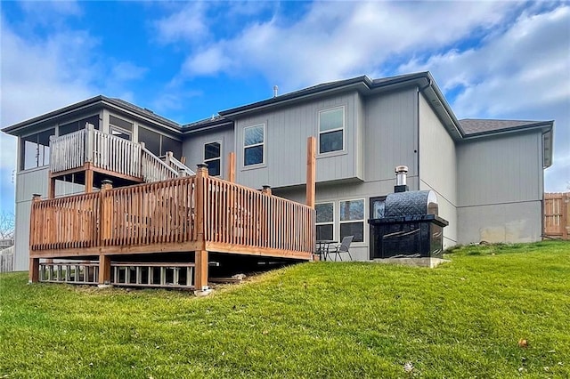 back of property with a wooden deck and a lawn