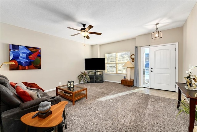 carpeted living room featuring ceiling fan and a textured ceiling