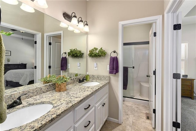 bathroom with tile patterned floors, a shower with door, and vanity