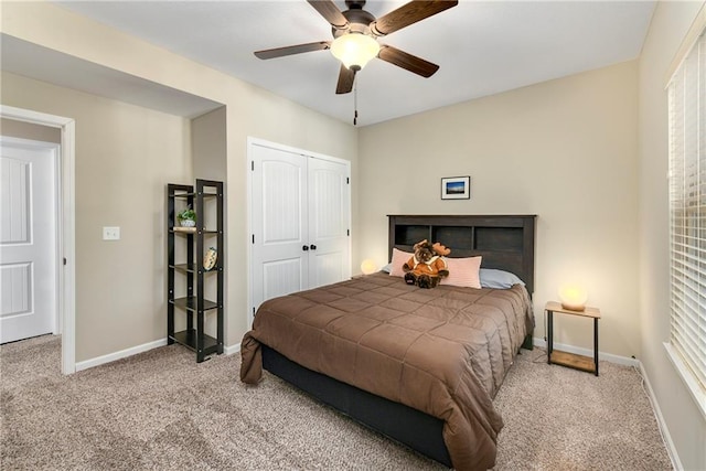 carpeted bedroom with ceiling fan and a closet