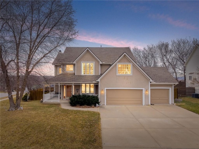 view of front of home featuring a garage, a lawn, central AC, and a porch