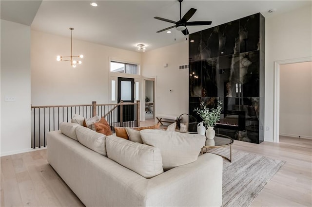 8309 NW 90th St, Kansas City, MO 64153 - living area with ceiling fan, light wood-type flooring, recessed lighting, a tiled fireplace, and a chandelier