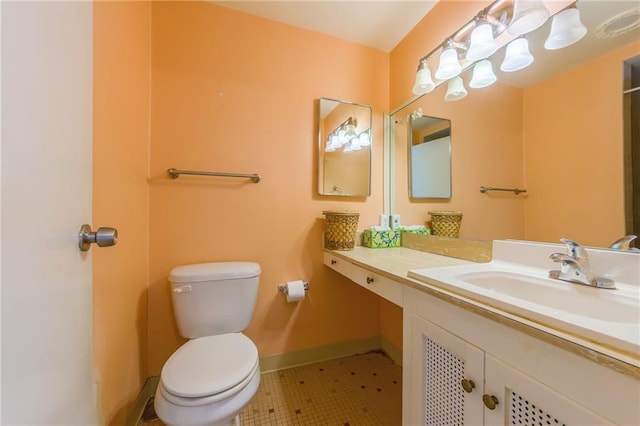 bathroom featuring toilet, vanity, and tile patterned flooring