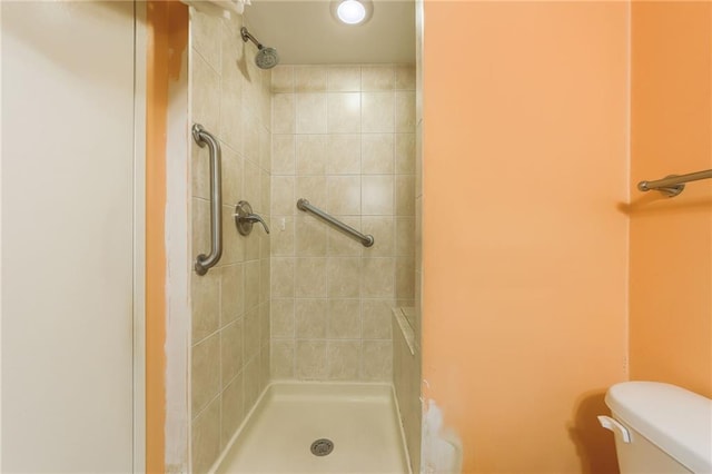 bathroom with toilet and a tile shower