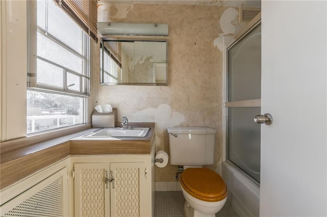 full bathroom with toilet, tile patterned floors, enclosed tub / shower combo, and vanity